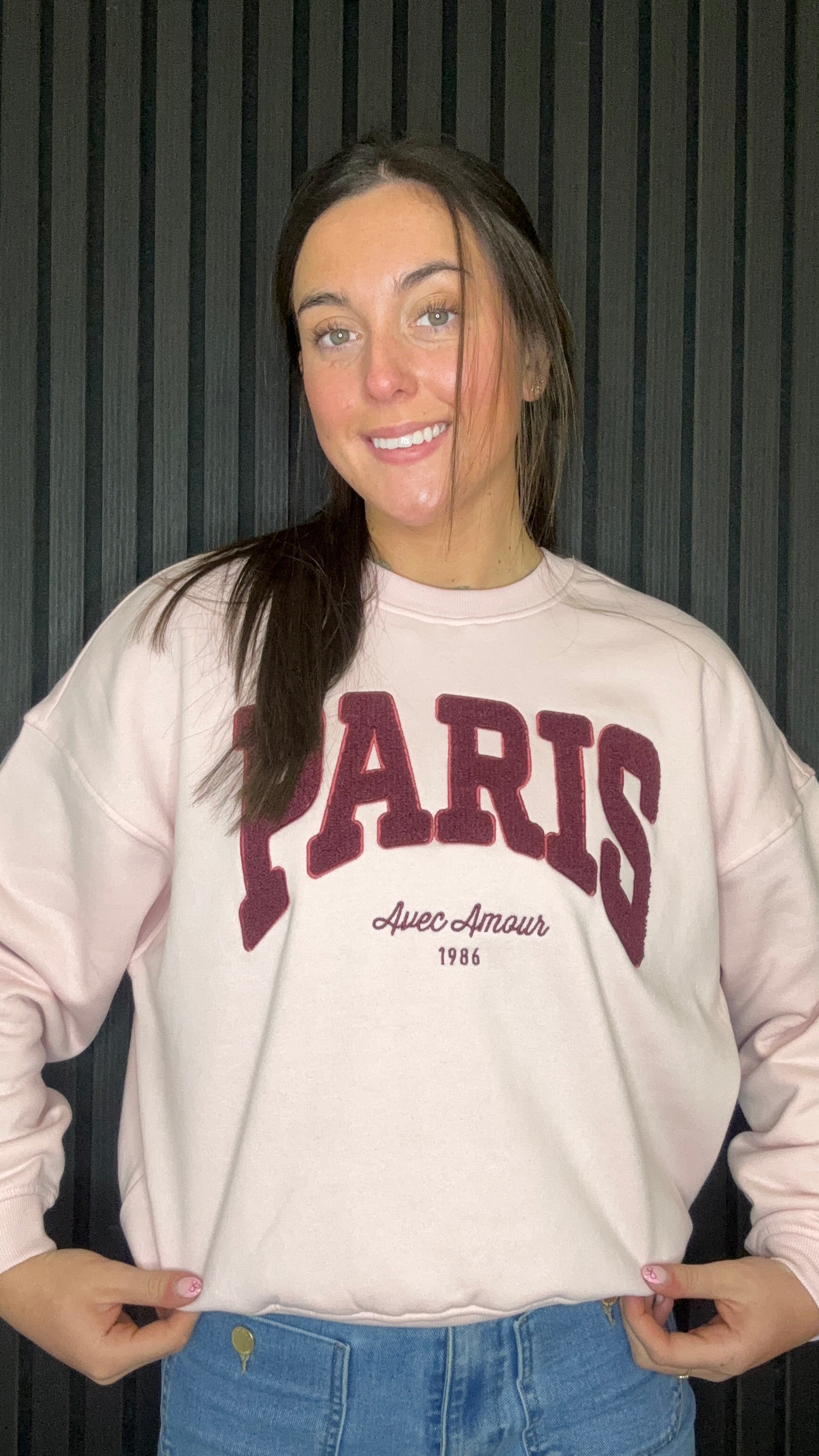 Close-up of chalk pink Paris sweatshirt with “Paris Avec Amour 1986” burgundy graphic, soft cotton fabric and crew neckline.