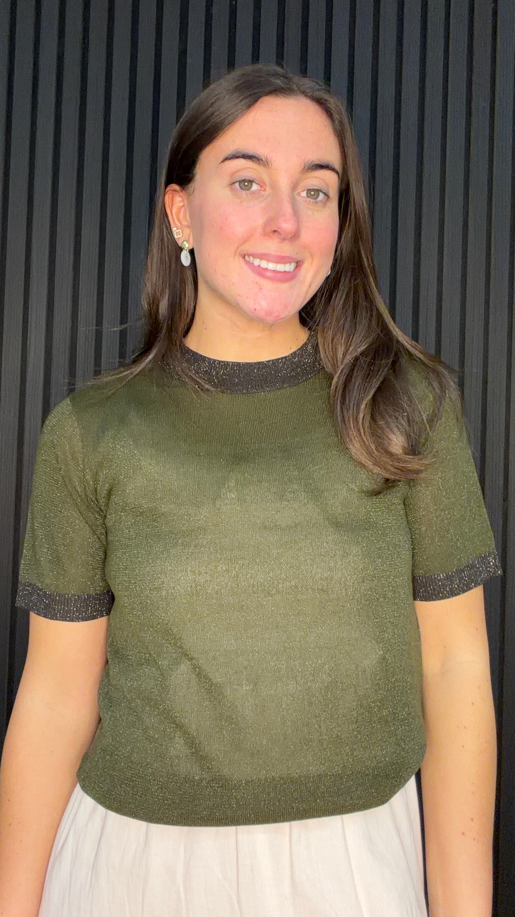 Model wearing the Bernie Contrast Glitter Knit Top in Dark Olive with glitter trim at the neckline and sleeves.