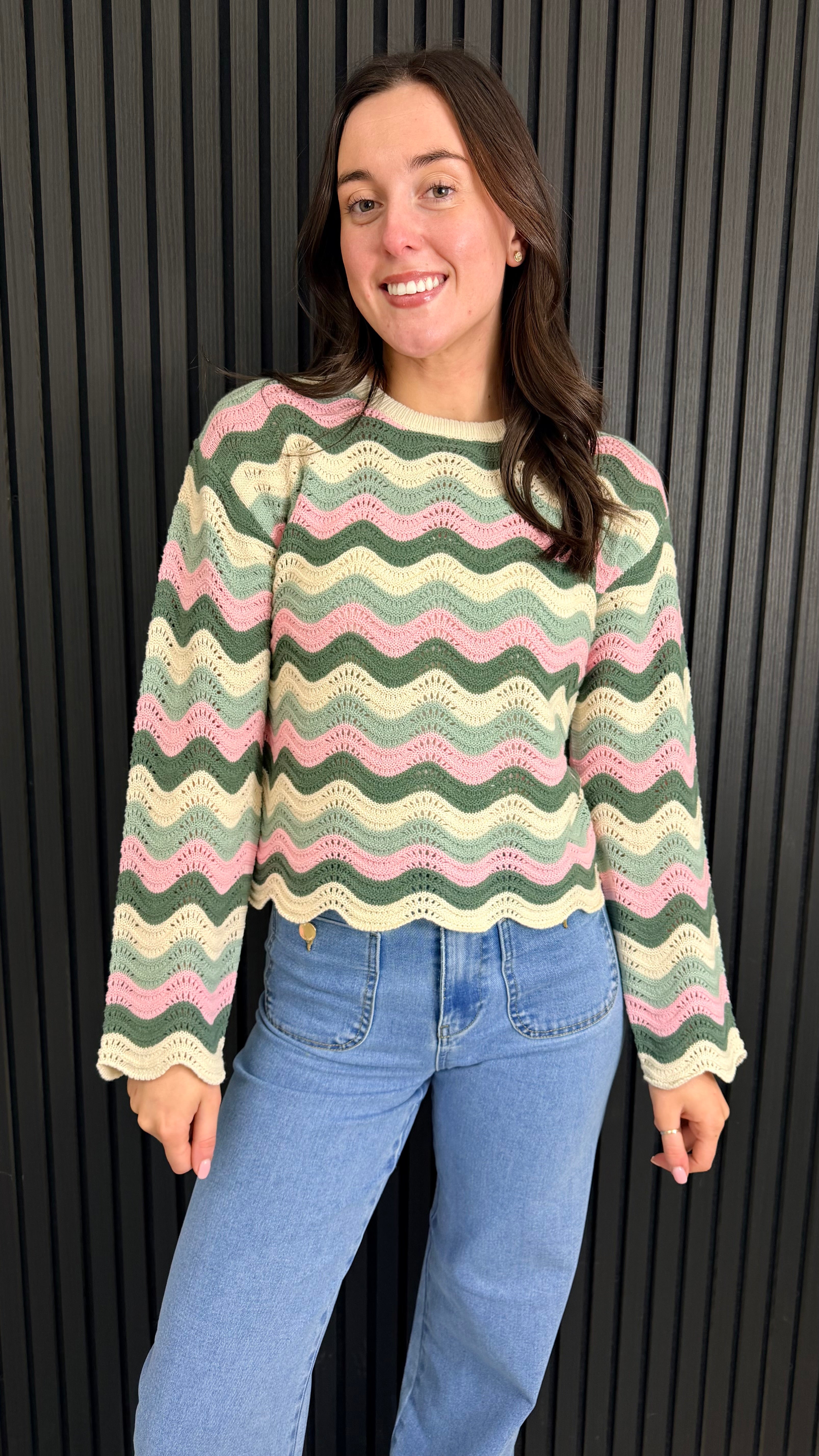 Front view of pink zigzag knit jumper on model