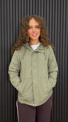 Women’s lightweight hooded jacket in khaki green with an adjustable waist, front zip and popper fastening, and practical side pockets.