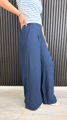 Side view of navy wide-leg trousers showing relaxed fit