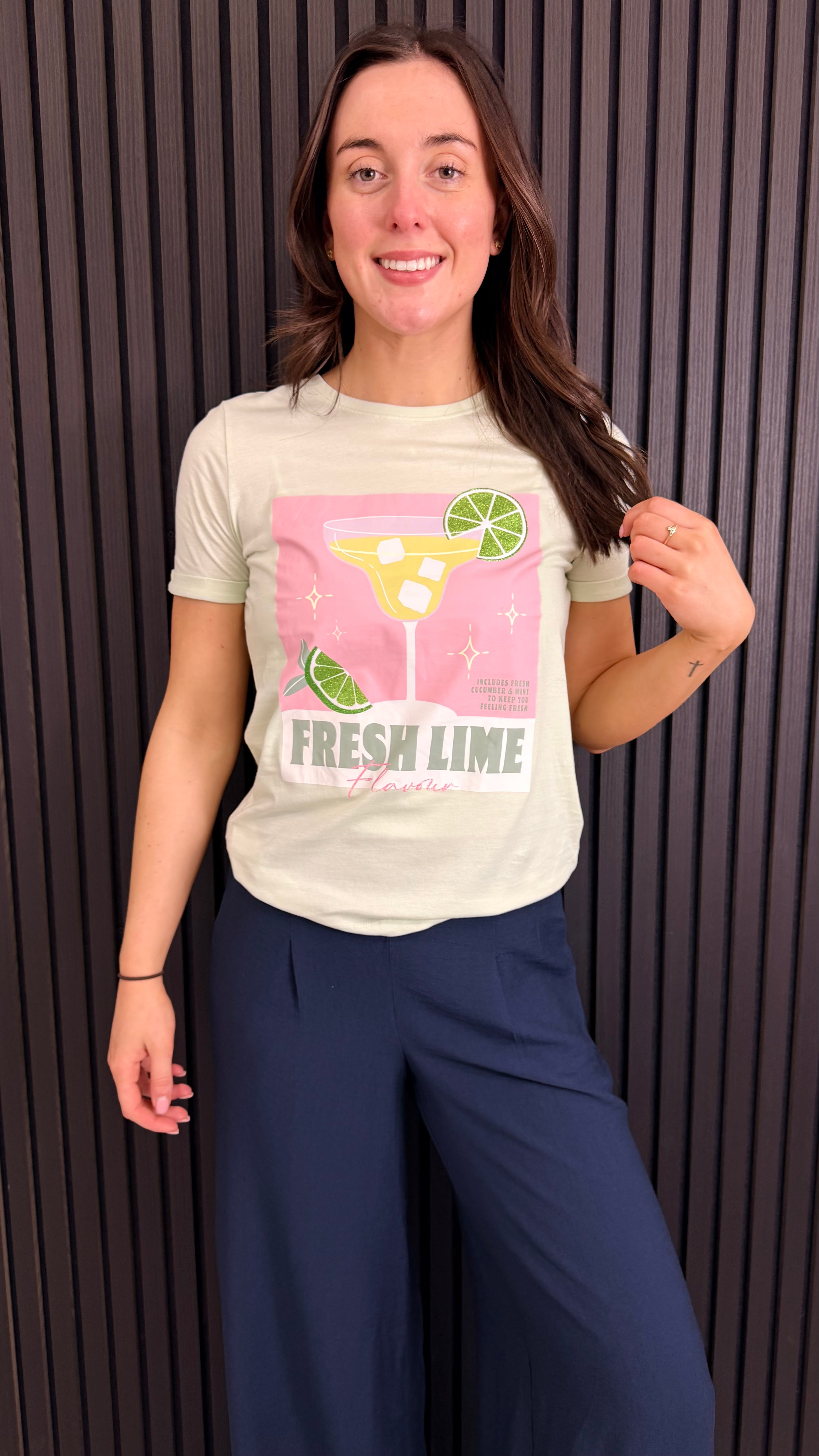 Front view of Fresh Lime graphic t-shirt styled with navy trousers.