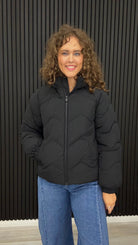 Paula black hooded puffer jacket with chevron quilted design.