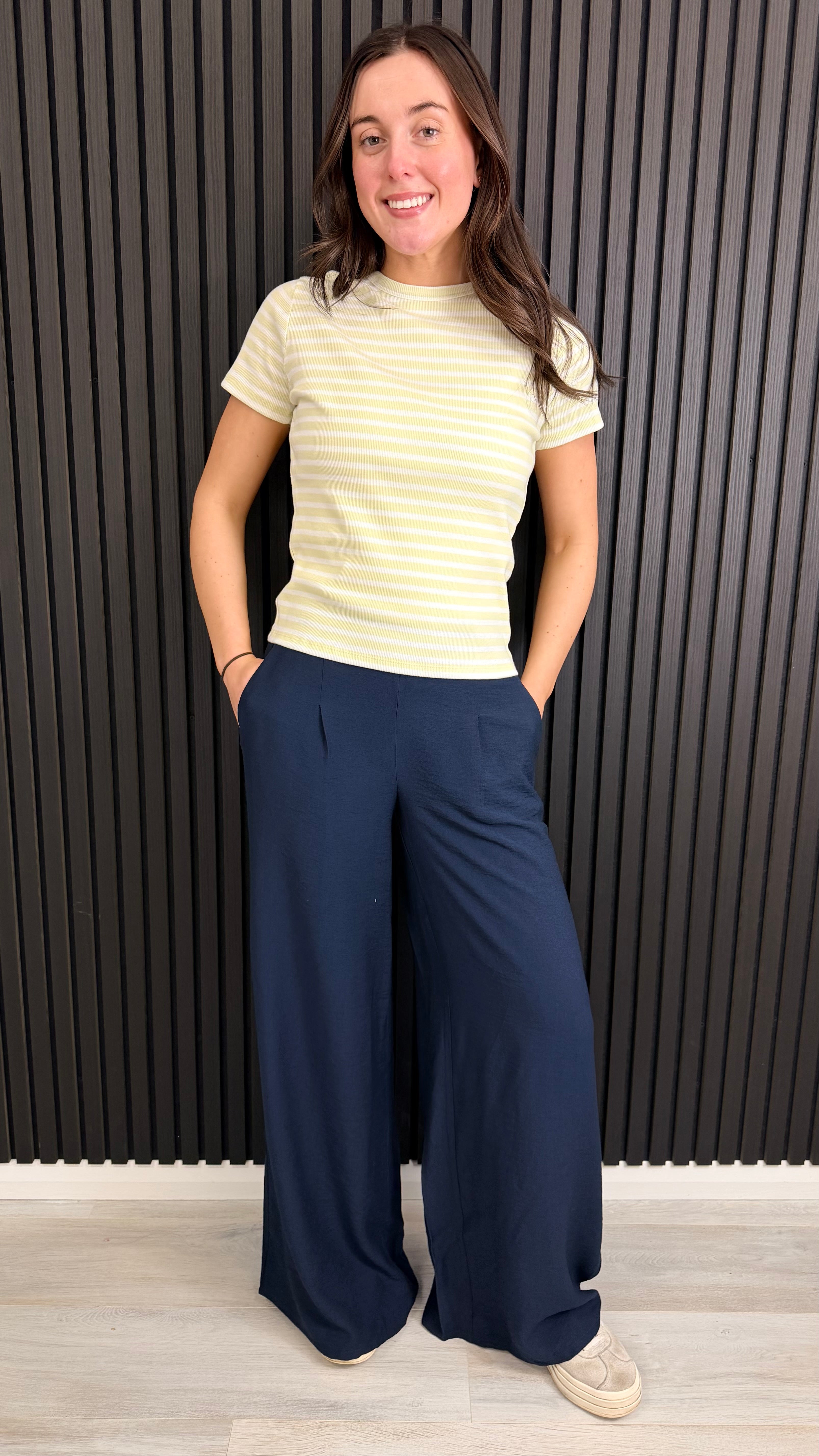 Woman wearing navy wide-leg trousers with a striped t-shirt