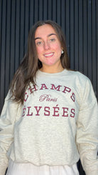 Model wearing the Maria Paris Sweatshirt in Oatmeal with a Champs-Élysées slogan print.