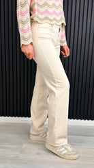 Side view of ecru straight-leg jeans with relaxed fit.