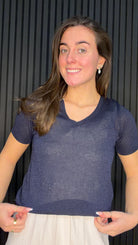 Model wearing the Brona Glitter Knit Top in navy with a V-neck and subtle shimmer finish.