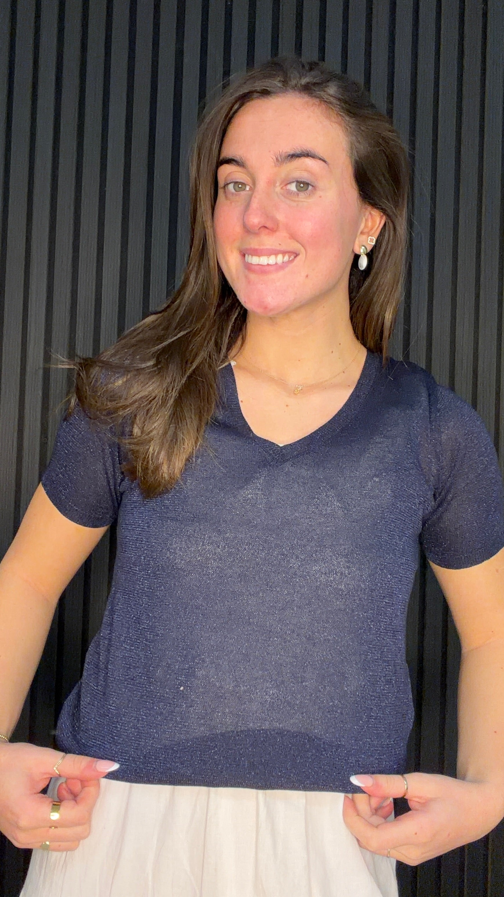 Model wearing the Brona Glitter Knit Top in navy with a V-neck and subtle shimmer finish.