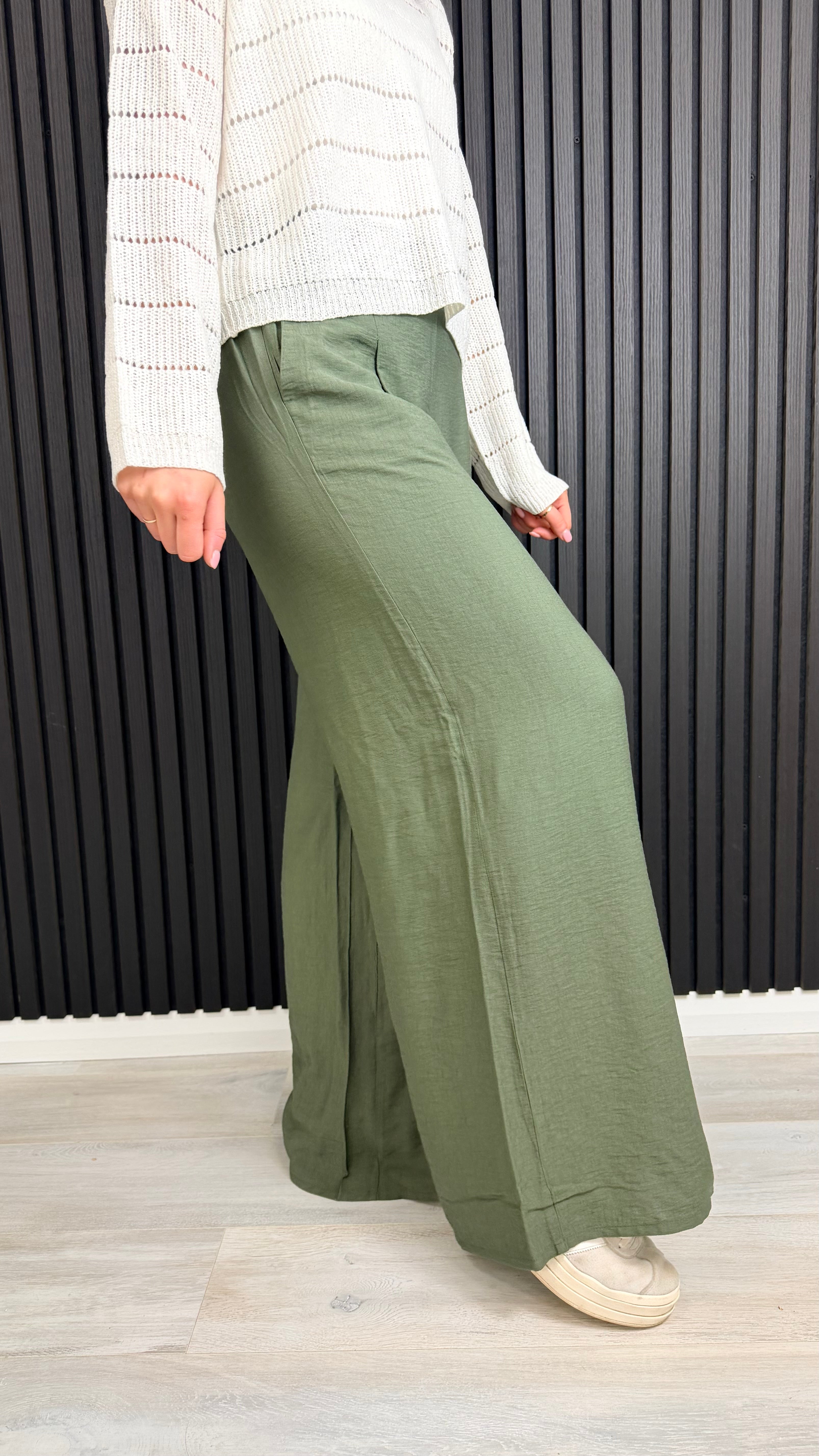 Side view of green wide-leg trousers showing relaxed fit