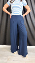 Navy wide-leg trousers styled casually with trainers