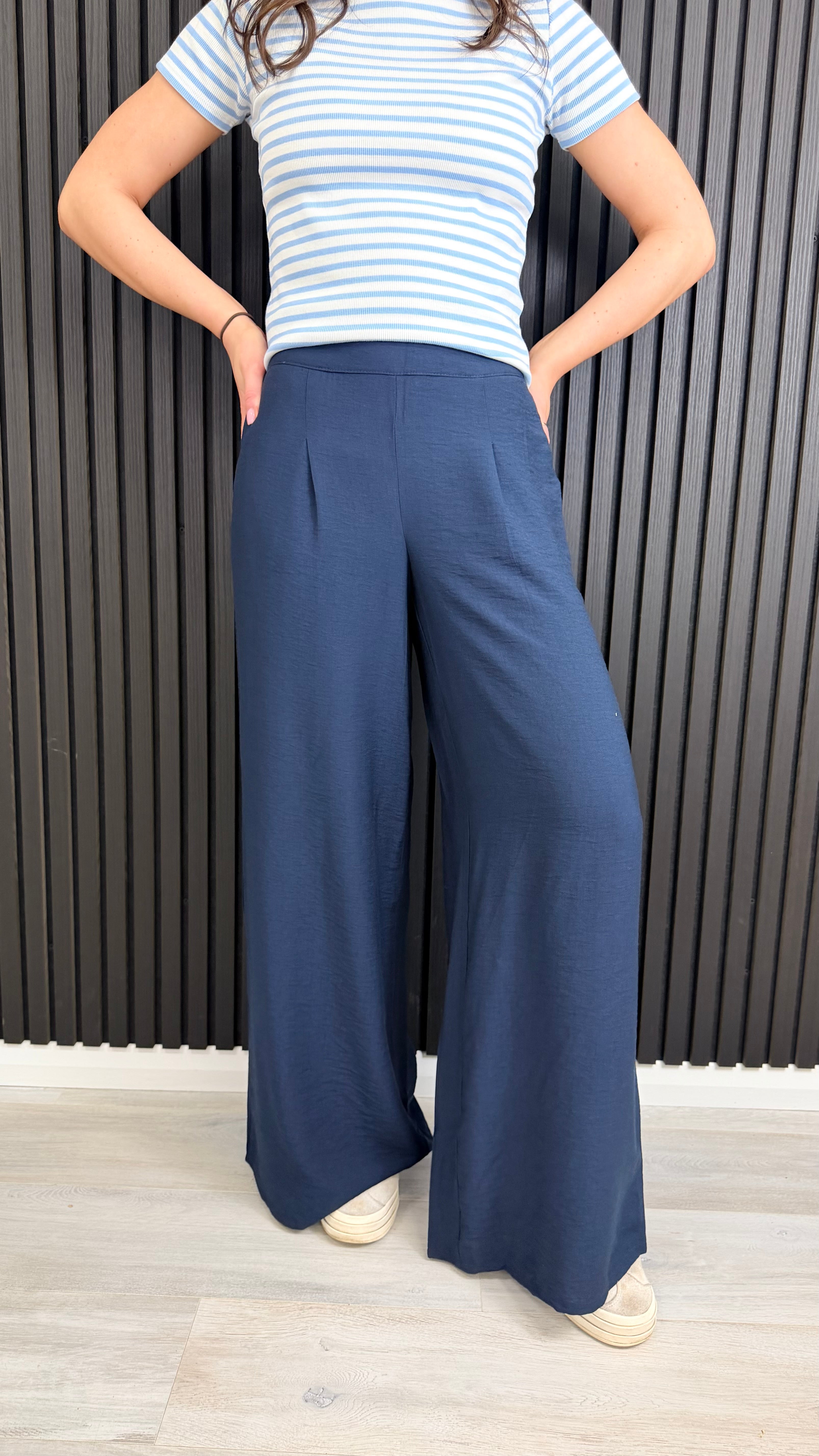 Navy wide-leg trousers styled casually with trainers