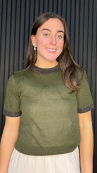 Model wearing the Bernie Contrast Glitter Knit Top in Dark Olive with glitter trim at the neckline and sleeves.